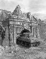 Tanks enter through the historic gate of old Fort Santiago injured by US shells as troops storm the City of Manila, Philippines. February 26, 1945